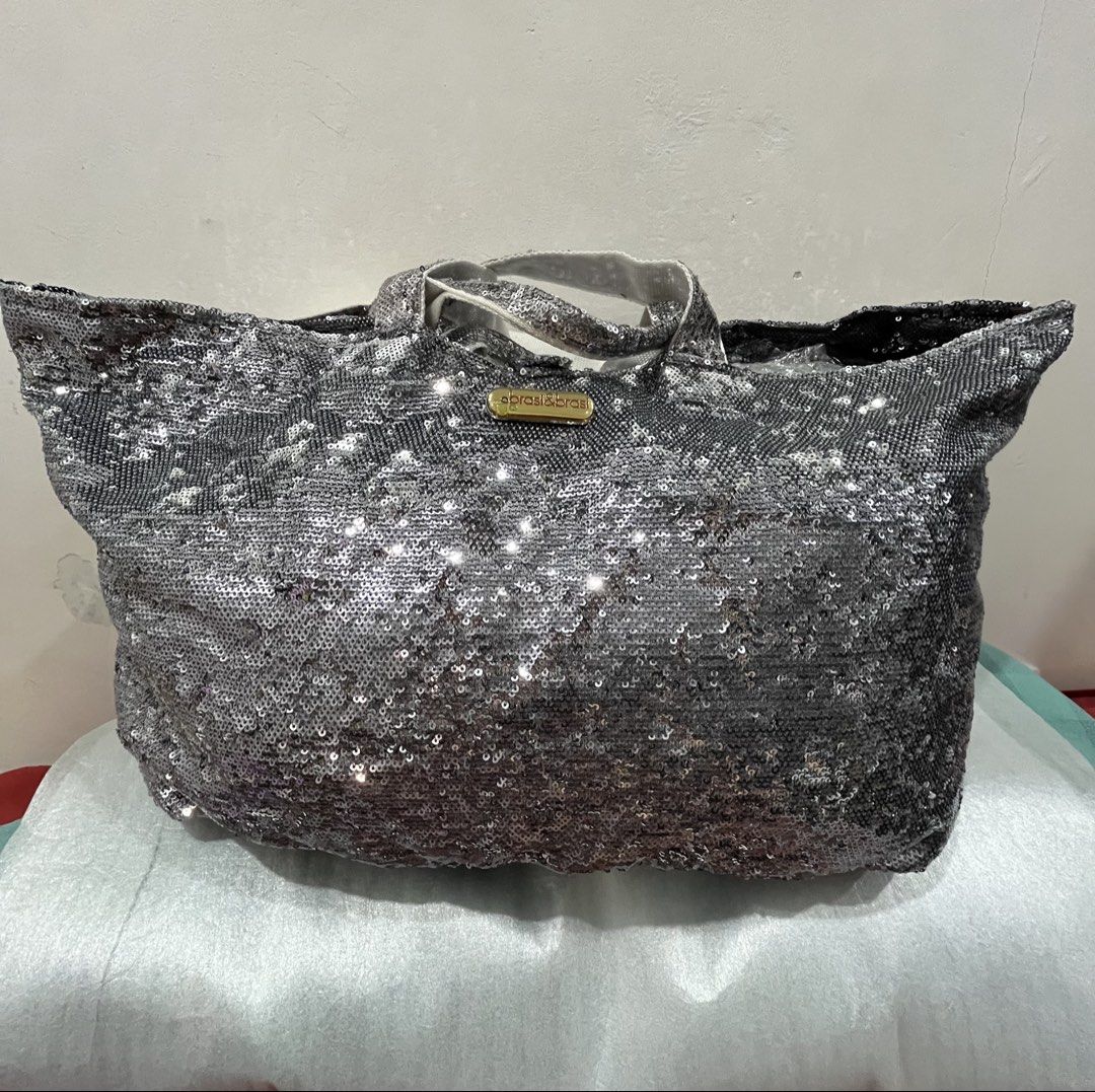 brasi & brasi Silver Sequin Tote Bag (Category: Tote Bags) located in Talisay. Submitted by cherylu (Listing ID 1469570294, Image 1). Description: - Brand: Brasi & Brasi - Material: Fully covered in silver sequins with gold-tone brand plaque - Interior: Dark brown fabric lining with an internal zip pocket - Straps: Dual top handles for easy carrying - Usage: Spacious and stylish, ideal for daily use or casual events.