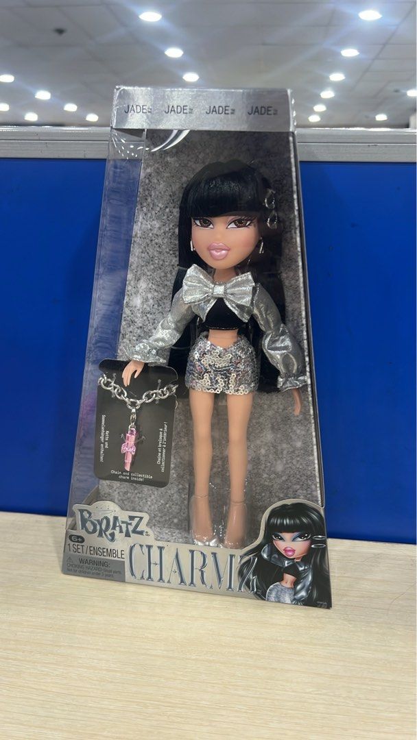 Bratz Charmz Jade Doll Unopened Box (Category: Kids Toys) located in Manila. Submitted by happydays.com (Listing ID 1469421143, Image 1). Description: - Brand: Bratz (Charmz Series - Jade) - Condition: Brand new, never removed from box (NRFB), crisp corners - Hair: Long black hair with signature bangs - Outfit: Metallic silver top, sparkly skirt, and matching heels - Accessories: Includes a chain necklace with a pink charm - Packaging: Clear fron