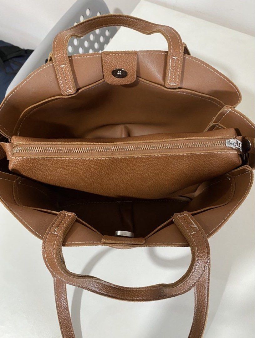 Brown dumpling bag (Category: Tote Bags) located in Manila. Submitted by pattydeclutters (Listing ID 1469411540, Image 2). Description: Material: Premium brown pebbled leather with stylish white contrast stitching Straps: Dual top carry handles and longer shoulder straps Closure: Secure magnetic snap Interior: Features a zippered middle compartment divider and convenient open side pockets Condition: 10/10 RFS: too many bags.
