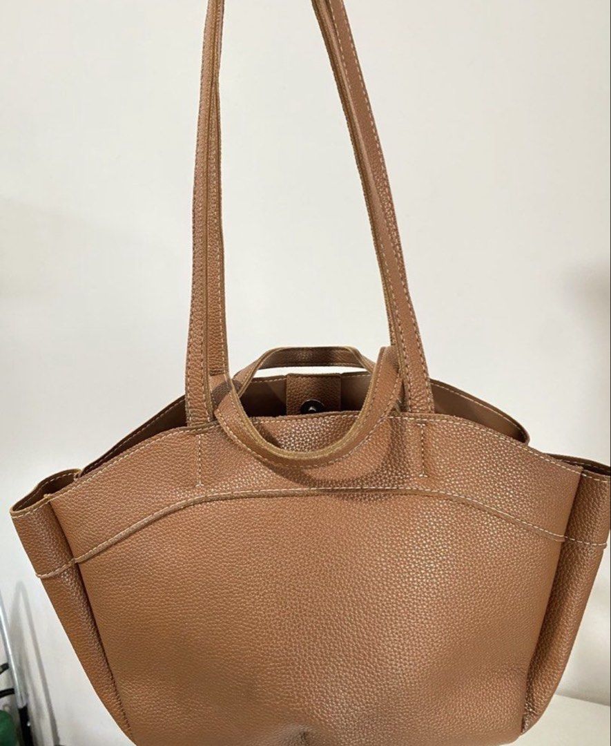 Brown dumpling bag (Category: Tote Bags) located in Manila. Submitted by pattydeclutters (Listing ID 1469411540, Image 3). Description: Material: Premium brown pebbled leather with stylish white contrast stitching Straps: Dual top carry handles and longer shoulder straps Closure: Secure magnetic snap Interior: Features a zippered middle compartment divider and convenient open side pockets Condition: 10/10 RFS: too many bags.