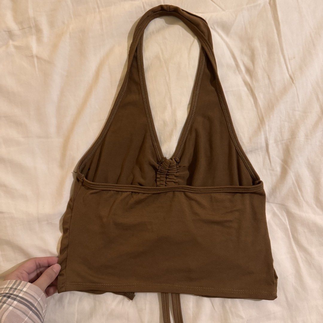 Brown Halter Crop Top with Ruching and Drawstring (Category: Sleeveless) located in Quezon City. Submitted by ianne.declutter (Listing ID 1469506787, Image 3). Description: - Style: Halter neck crop top with V-neckline - Color: Brown - Details: Ruched front, adjustable drawstring split hem, and horizontal back strap - Fit: Soft, stretchy fabric for ultimate comfort - Versatility: Great for casual days or nights out, easy to pair with high-waisted