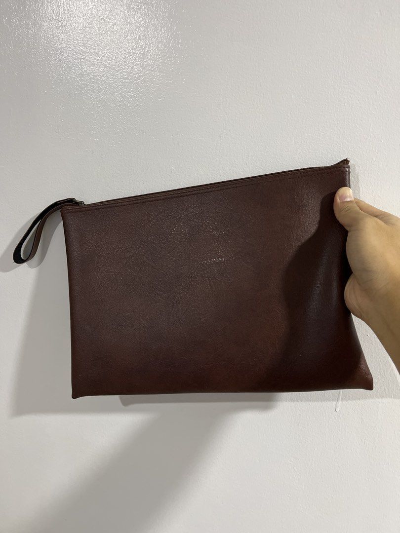 Brown Leather Clutch Bag with Wrist Strap (Category: Clutches) located in Manila. Submitted by curated.clutter12 (Listing ID 1469516675, Image 1). Description: - Color: Dark brown - Material: Smooth faux leather with a subtle grain pattern - Closure: Secure top zipper - Features: Attached side wrist strap, clean interior lining - Capacity: Slim profile, perfect for phone, cards, and keys - Style: Grab-and-go everyday clutch.