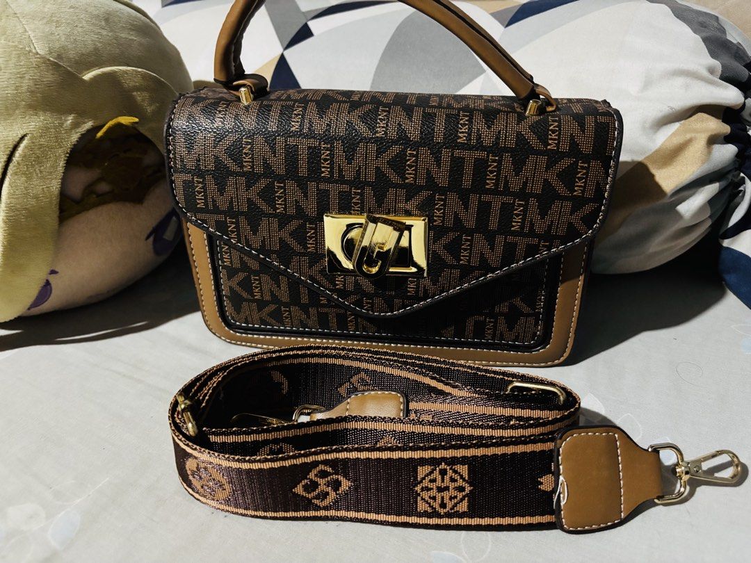 Brown Monogram MKNT Top Handle Crossbody Bag (Category: Cross-body Bags) located in Manila. Submitted by cleverdog_2c1729 (Listing ID 1469515648, Image 1). Description: - Brown patterned crossbody bag with repeating MKNT print - Elegant gold-tone metal clasp closure on the front flap - Premium tan leather trim along the edges and top handle - Comes with a detachable brown and tan patterned fabric strap - Structured shape with a clean, polished fi