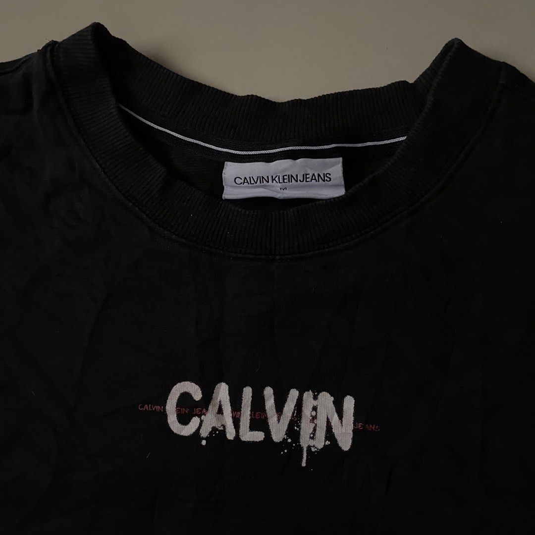 Calvin Klein Graphic tee (Category: Formal Shirts) located in Iligan City. Submitted by renzreyong66220 (Listing ID 1469444238, Image 3). Description: - Brand: Calvin Klein Jeans - Condition: Brand new with interior tags and care labels - Size: Medium - Color: Black - Front: Small Calvin logo print on the chest - Back: Large statement triple LOVE graphic print with ck branding - Sleeve: Small embroidered ck logo on the left sleeve - Neckline: Cre