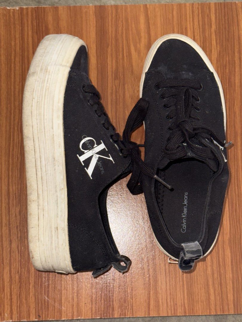 Calvin Klein Jeans black platform sneakers (Category: Sneakers) located in Batangas. Submitted by ystyledx (Listing ID 1469568255, Image 3). Description: - Brand: Calvin Klein Jeans - Style: Black canvas platform sneakers with chunky white soles - Details: White CK logo on the sides, black laces, and heel pull tabs - Condition: Minor scuffing on the platform soles - Fit: Comfortable for everyday wear.