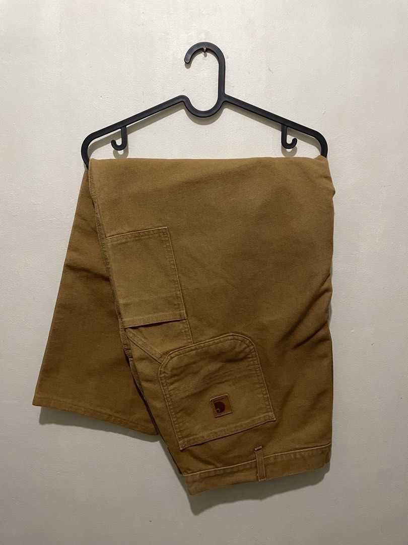 Carhartt Brown Duck Canvas Carpenter Pants (Category: Jeans) located in Manila. Submitted by bigboyzcloset (Listing ID 1469417756, Image 1). Description: - Brand: Carhartt - Style: Duck canvas carpenter pants / utility trousers - Color: Classic brown - Features: Heavyweight durable fabric, tool pockets, hammer loop, and triple-stitched seams - Details: Branded metal button closure and signature leather logo patch on rear pocket - Fit: Structured 