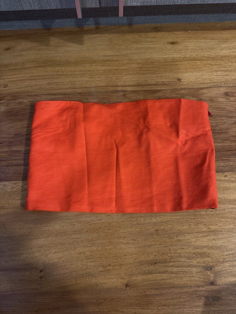 Cariño Anita Tube (Category: Sleeveless) located in Makati City. Submitted by kkk.shops (Listing ID 1469509562, Image 2). Description: - Color: Vibrant red-orange - Style: Strapless tube top with a sleek fitted cut - Closure: Convenient side zipper - Features: Structured shape and clean hem - Versatility: Perfect for warmer weather or night outs; pairs easily with high-waisted bottoms.