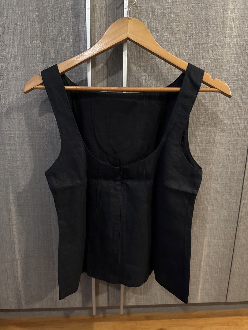 Cariño Linen Top (Category: Sleeveless) located in Makati City. Submitted by kkk.shops (Listing ID 1469512759, Image 2). Description: - Color: Solid black - Design: Sleeveless with scoop back - Closure: Back zipper for easy wear - Material: Structured fabric with wide shoulder straps - Style: Clean minimalist design that goes with everything - Versatility: Great for daily outfits or layering under blazers.