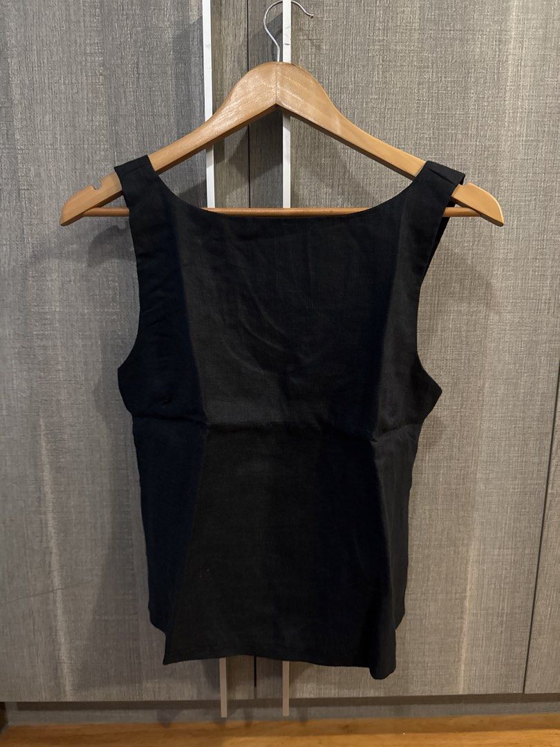 Cariño Linen Top (Category: Sleeveless) located in Makati City. Submitted by kkk.shops (Listing ID 1469512759, Image 1). Description: - Color: Solid black - Design: Sleeveless with scoop back - Closure: Back zipper for easy wear - Material: Structured fabric with wide shoulder straps - Style: Clean minimalist design that goes with everything - Versatility: Great for daily outfits or layering under blazers.