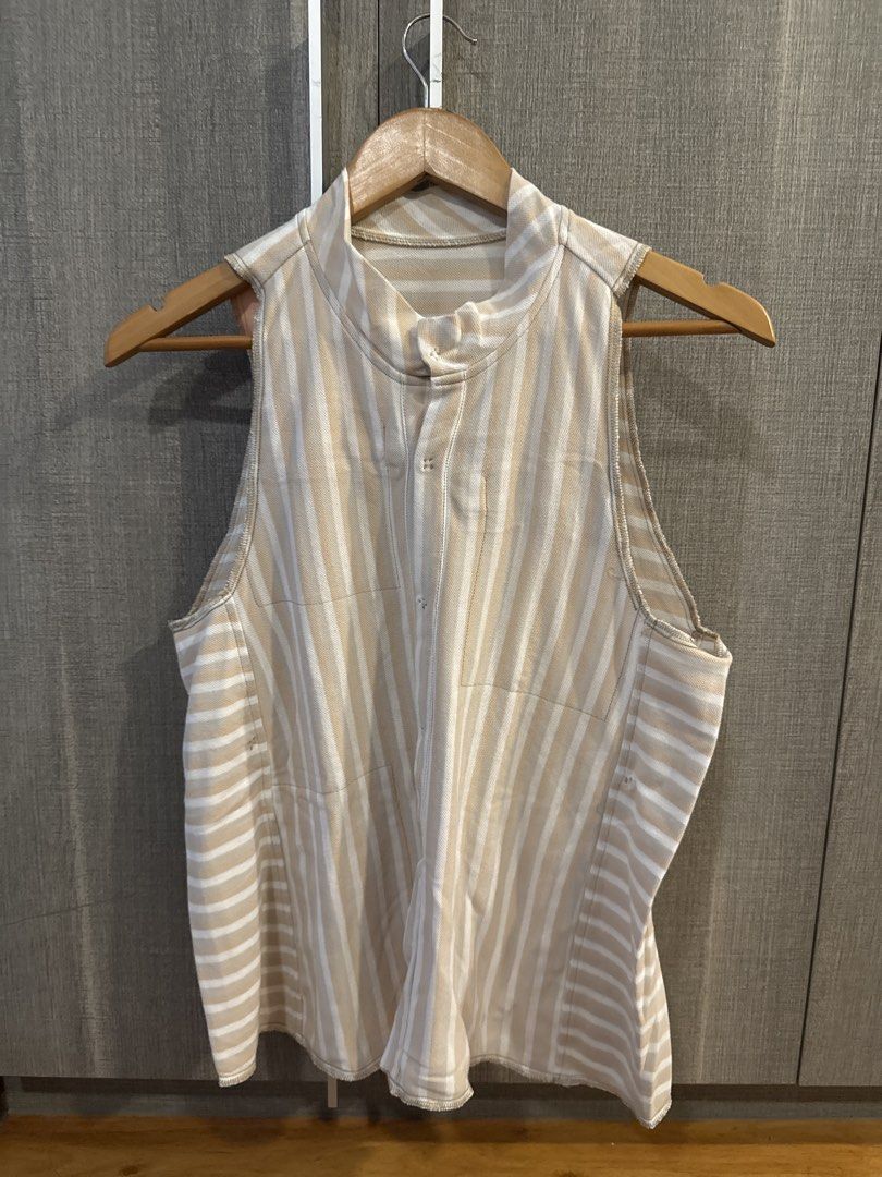 Carl Jan Cruz Top (Category: Sleeveless) located in Makati City. Submitted by kkk.shops (Listing ID 1469511117, Image 1). Description: - Color/Pattern: Beige and white with mixed vertical (front) and horizontal (back) stripes - Design: Sleeveless with a chic mock neckline and front button placket - Fit: Relaxed and comfortable - Fabric: Lightweight, textured material - Style: Versatile and easy to dress up or down for casual days.