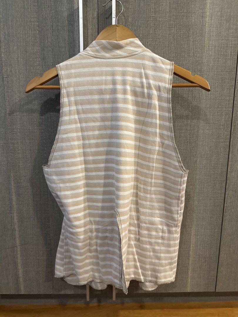 Carl Jan Cruz Top (Category: Sleeveless) located in Makati City. Submitted by kkk.shops (Listing ID 1469511117, Image 2). Description: - Color/Pattern: Beige and white with mixed vertical (front) and horizontal (back) stripes - Design: Sleeveless with a chic mock neckline and front button placket - Fit: Relaxed and comfortable - Fabric: Lightweight, textured material - Style: Versatile and easy to dress up or down for casual days.
