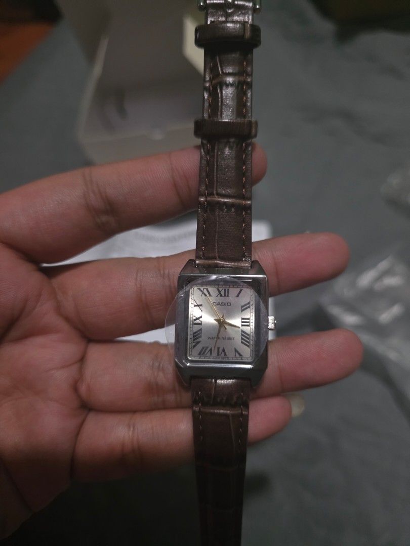 Casio LTP-V007 Rectangular Roman Numeral Watch (Category: Women's Watches) located in Manila. Submitted by biiiiiilllyyy (Listing ID 1469517199, Image 1). Description: - Model: Casio LTP-V007 women's watch - Condition: Brand new with protective plastic film on the crystal - Design: Rectangular silver-tone case with a white dial and classic Roman numerals - Strap: Brown leather strap with a stylish croc texture - Features: Water-resistant back - I