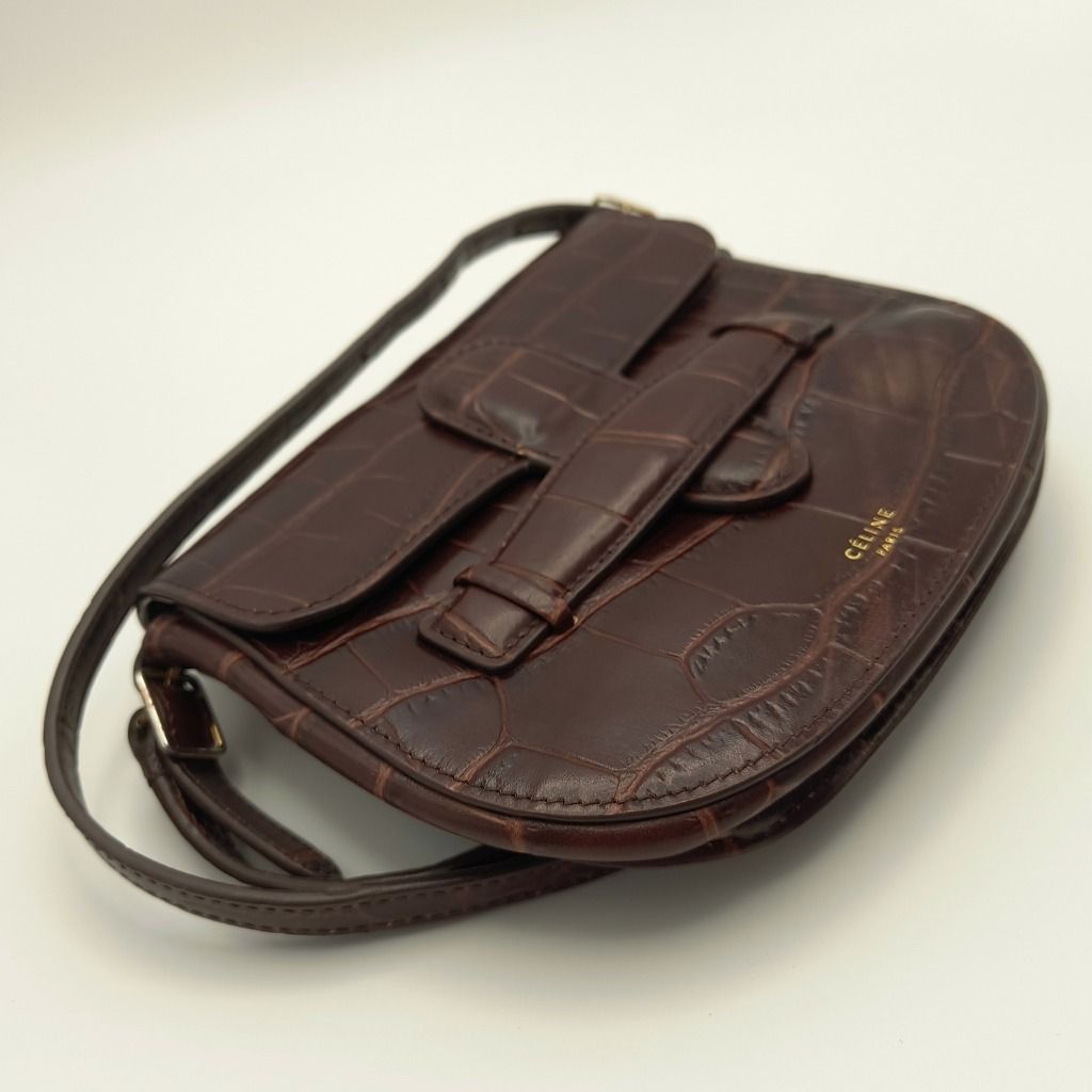 Celine Mini Symmetrical Bag Brown Croc (Category: Luxury Bags & Wallets) located in Lapu Lapu. Submitted by theluxxaffair (Listing ID 1469541156, Image 2). Description: Guaranteed authentic Celine Symmetrical Mini Bag in deep brown (walnut) crocodile-embossed leather. A compact structured crossbody silhouette featuring the signature symmetrical belt detail, gold-tone hardware, and a slim adjustable strap. Can be worn crossbody or converted into a