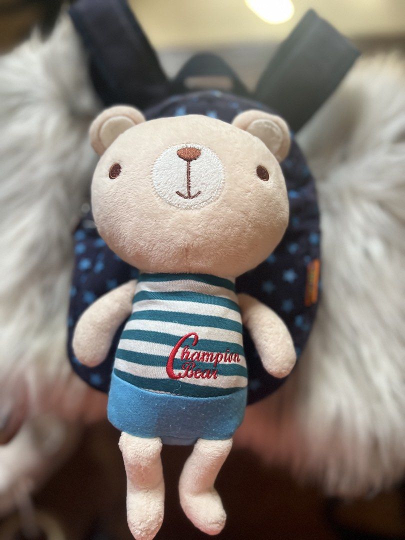 Champion Bear Blue Star Print Mini Backpack with Plush Toy (Category: Backpacks) located in Rizal. Submitted by safecat_3c0d85 (Listing ID 1469430242, Image 1). Description: - Color/Design: Navy blue with light blue star prints - Inclusion: Comes with an attached Champion Bear plush toy in a striped shirt and blue shorts - Details: Branded zipper pull and interior logo patch - Compartments: Secure main zipper closure with a lined interior and a z