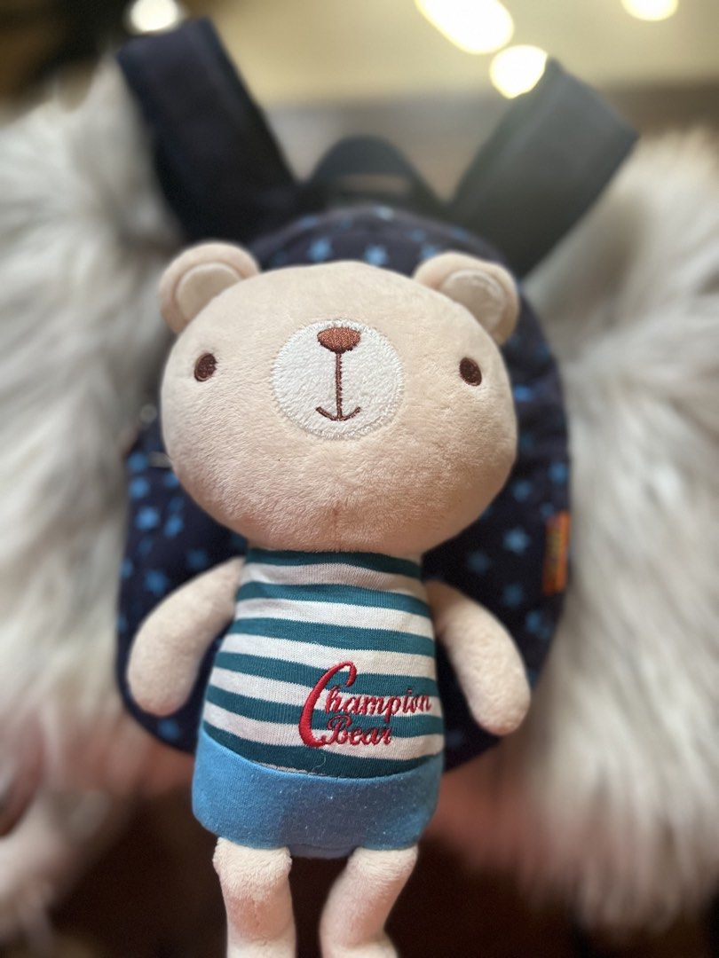 Champion Bear Blue Star Print Mini Backpack with Plush Toy (Category: Backpacks) located in Rizal. Submitted by safecat_3c0d85 (Listing ID 1469430242, Image 2). Description: - Color/Design: Navy blue with light blue star prints - Inclusion: Comes with an attached Champion Bear plush toy in a striped shirt and blue shorts - Details: Branded zipper pull and interior logo patch - Compartments: Secure main zipper closure with a lined interior and a z