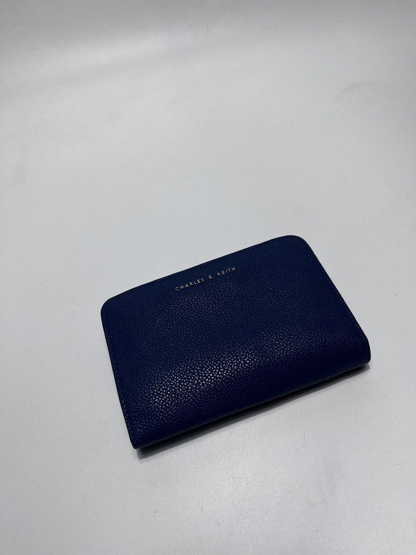 Charles & Keith Blue Wallet (Category: Wallets & Card holders) located in Iloilo. Submitted by fromthebins.ilo2 (Listing ID 1469464171, Image 1). Description: - Brand/Model: Charles & Keith Wallet - Color: Navy blue - Material: Textured leather finish - Closure: Secure snap button on main flap - Interior: Multiple card slots on both sides and clean blue lining - Compartments: Separate zippered pocket for coins and folded cash - Design: Compact si