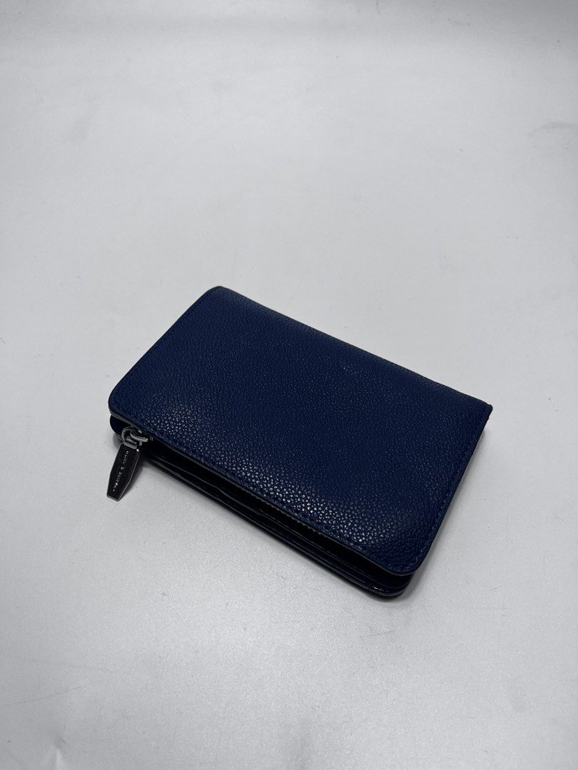 Charles & Keith Blue Wallet (Category: Wallets & Card holders) located in Iloilo. Submitted by fromthebins.ilo2 (Listing ID 1469464171, Image 2). Description: - Brand/Model: Charles & Keith Wallet - Color: Navy blue - Material: Textured leather finish - Closure: Secure snap button on main flap - Interior: Multiple card slots on both sides and clean blue lining - Compartments: Separate zippered pocket for coins and folded cash - Design: Compact si