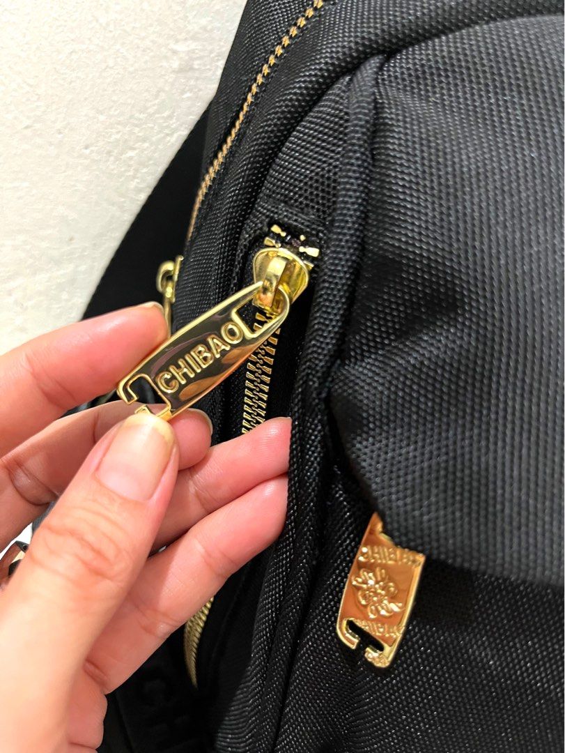 Chibao Black Nylon Mini Backpack with Gold Hardware (Category: Backpacks) located in Talisay. Submitted by cherylu (Listing ID 1469403289, Image 3). Description: - Brand: Chibao - Material: Durable black nylon with luxury gold hardware accents - Straps: Stylish woven 'CHIBAO' lettering straps - Compartments: Secure main zipped compartment, interior zip pocket, and slip pocket - Interior: Branded grey fabric lining - Use: Compact and perfect for e