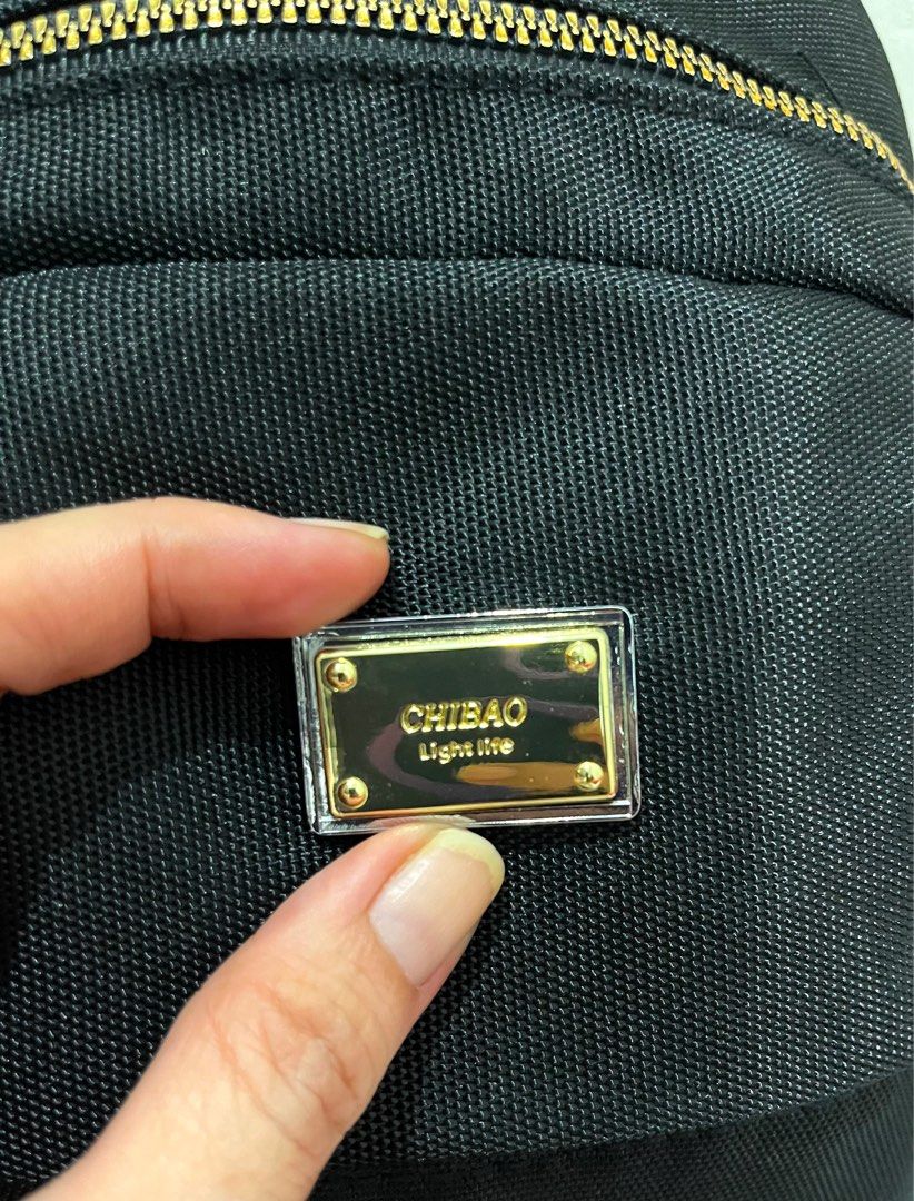 Chibao Black Nylon Mini Backpack with Gold Hardware (Category: Backpacks) located in Talisay. Submitted by cherylu (Listing ID 1469403289, Image 2). Description: - Brand: Chibao - Material: Durable black nylon with luxury gold hardware accents - Straps: Stylish woven 'CHIBAO' lettering straps - Compartments: Secure main zipped compartment, interior zip pocket, and slip pocket - Interior: Branded grey fabric lining - Use: Compact and perfect for e