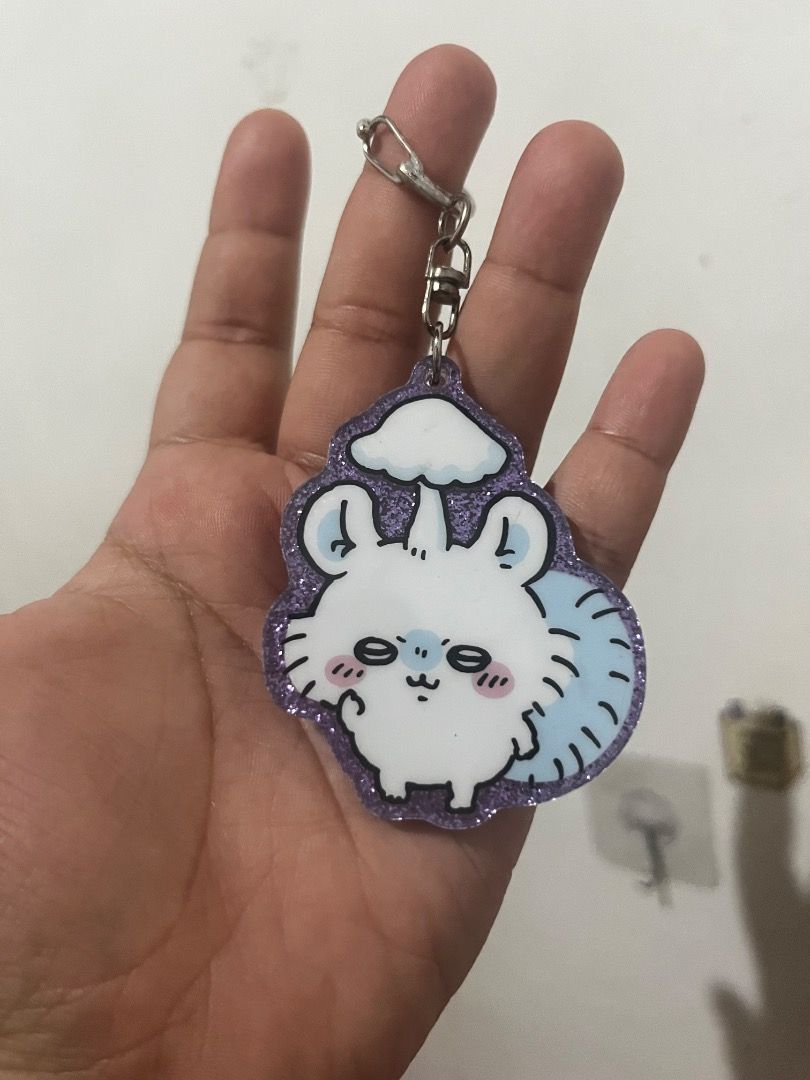 Chiikawa Momonga Glitter Acrylic Keychain Charm (Category: Character Goods) located in Tarlac. Submitted by theoshawott_adventureph (Listing ID 1469512735, Image 1). Description: - Character: Momonga from Chiikawa - Material: Clear acrylic with purple glitter backing - Hardware: Sturdy metallic clasp - Authenticity: Official merch marked Chiikawa and Kitan China on the back - Usage: Perfect accessory for bags, keys, or lanyards - Condition: Brand
