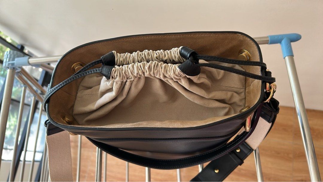 Chloé Black Leather Bucket Bag (Category: Luxury Bags & Wallets) located in Las Pinas. Submitted by emwcuabc (Listing ID 1469507227, Image 2). Description: - Color & Material: Black leather body with cream fabric drawstring pouch and beige interior lining - Hardware: Premium gold-tone rings on the sides with zero scuffs - Straps: Includes both a thick neutral canvas shoulder strap and sturdy leather handles - Interior: Features a secure zippered 