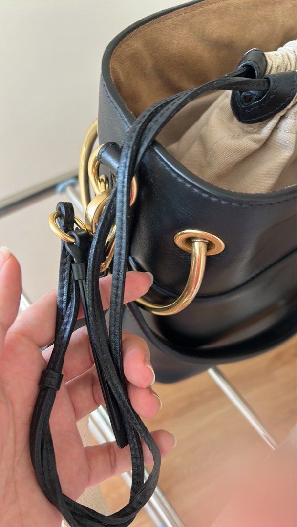 Chloé Black Leather Bucket Bag (Category: Luxury Bags & Wallets) located in Las Pinas. Submitted by emwcuabc (Listing ID 1469507227, Image 3). Description: - Color & Material: Black leather body with cream fabric drawstring pouch and beige interior lining - Hardware: Premium gold-tone rings on the sides with zero scuffs - Straps: Includes both a thick neutral canvas shoulder strap and sturdy leather handles - Interior: Features a secure zippered 