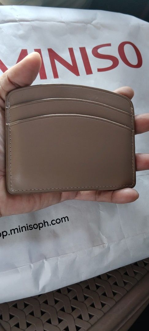 Christy Ng yuki card walet (Category: Wallets & Card holders) located in Manila. Submitted by roserallos42594 (Listing ID 1469464273, Image 2). Description: - Material: Premium brown faux leather - Storage: Multiple card slots on both front and back - Accent: Elegant small gold metal logo plaque at the bottom edge - Design: Compact and slim, easily fits into small bags and pockets.