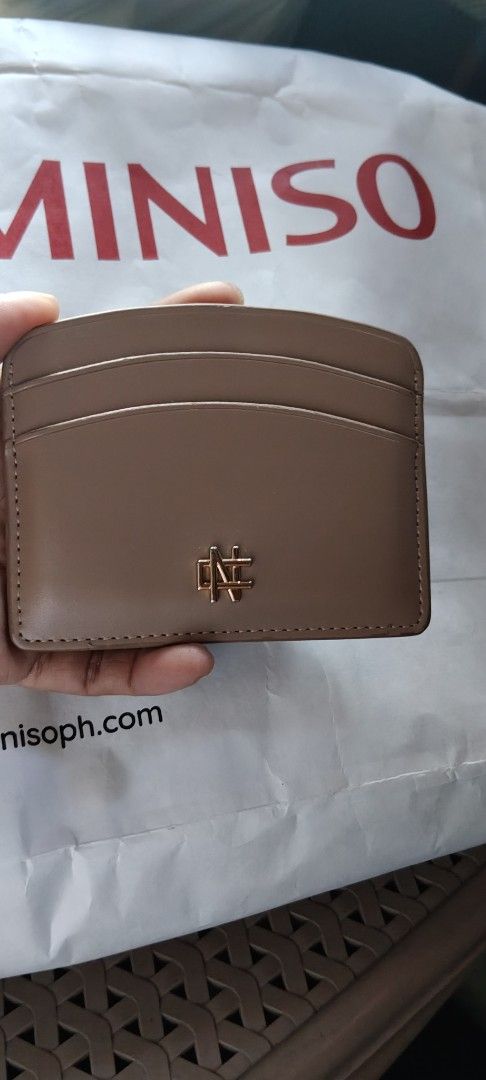 Christy Ng yuki card walet (Category: Wallets & Card holders) located in Manila. Submitted by roserallos42594 (Listing ID 1469464273, Image 1). Description: - Material: Premium brown faux leather - Storage: Multiple card slots on both front and back - Accent: Elegant small gold metal logo plaque at the bottom edge - Design: Compact and slim, easily fits into small bags and pockets.
