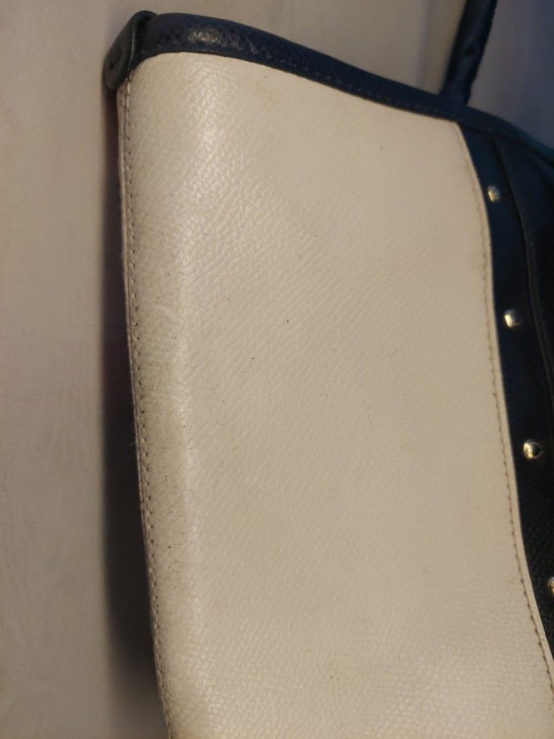 Coach Blue and White Tote Bag (Category: Tote Bags) located in Quezon City. Submitted by never_a_clutter (Listing ID 1469532240, Image 2). Description: Authentic Coach tote bag in blue and white leather. Gold-tone hardware accents along the front panel. Handles wrapped in fabric with matching blue color because of it's flaw (MEDYO MALAGKIT) Visible scuffs and wear along the white leather edges and corners. - Little pen marks on the side. - all sm