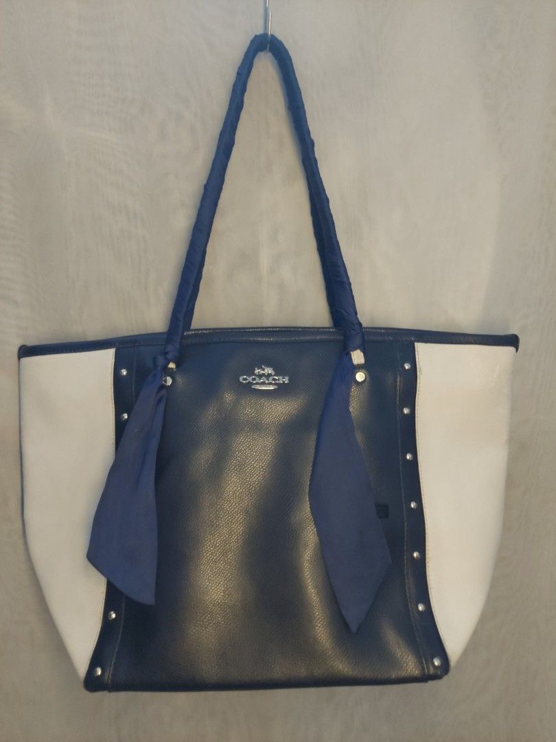 Coach Blue and White Tote Bag (Category: Tote Bags) located in Quezon City. Submitted by never_a_clutter (Listing ID 1469532240, Image 1). Description: Authentic Coach tote bag in blue and white leather. Gold-tone hardware accents along the front panel. Handles wrapped in fabric with matching blue color because of it's flaw (MEDYO MALAGKIT) Visible scuffs and wear along the white leather edges and corners. - Little pen marks on the side. - all sm