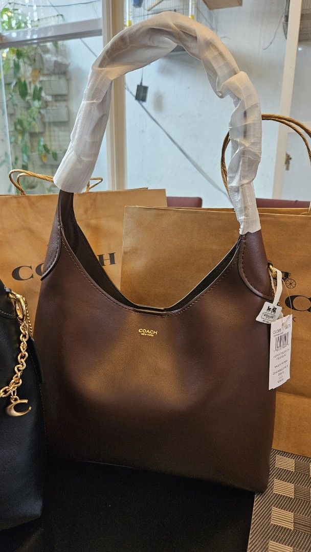 Coach Brooklyn (Category: Luxury Bags & Wallets) located in Rizal. Submitted by vanbdc24 (Listing ID 1469506100, Image 2). Description: - Brand: Coach - Styles: Leather shoulder bags with clean silhouettes and subtle Coach New York branding size 28, 34 and 39 - Colors available: Black, Dark Brown, and Burgundy - Hardware: Premium gold-tone hardware - Condition: Brand new, handles wrapped in protective packaging (one black bag styled with a bonus 