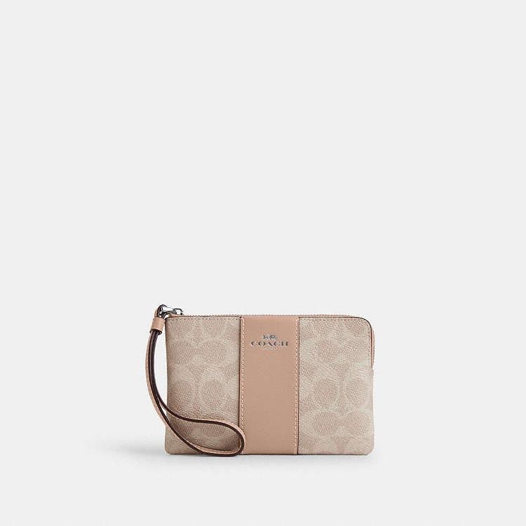 Coach Corner Zip Wristlet (Category: Wallets & Card holders) located in Las Pinas. Submitted by shopwithmira13 (Listing ID 1469509721, Image 3). Description: - Authentic Coach signature monogram coated canvas in dark brown - Stylish solid black center vertical stripe and matching black wrist strap - Elegant gold-tone hardware and secure zip closure - Iconic Coach New York logo stamped in gold on the front - Compact and convenient size for cards, 