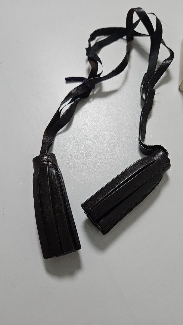 Coach Leather Tassel Bag Charm (Category: Wallets & Card holders) located in Alfonso. Submitted by jbcamet (Listing ID 1469516041, Image 3). Description: - Brand: Genuine Coach Leatherware - Color: Dark brown - Inclusions: Original beige box included - Features: Long straps, classic design, and high-quality finish - Perfect for: Upgrading and styling plain tote or shoulder bags.