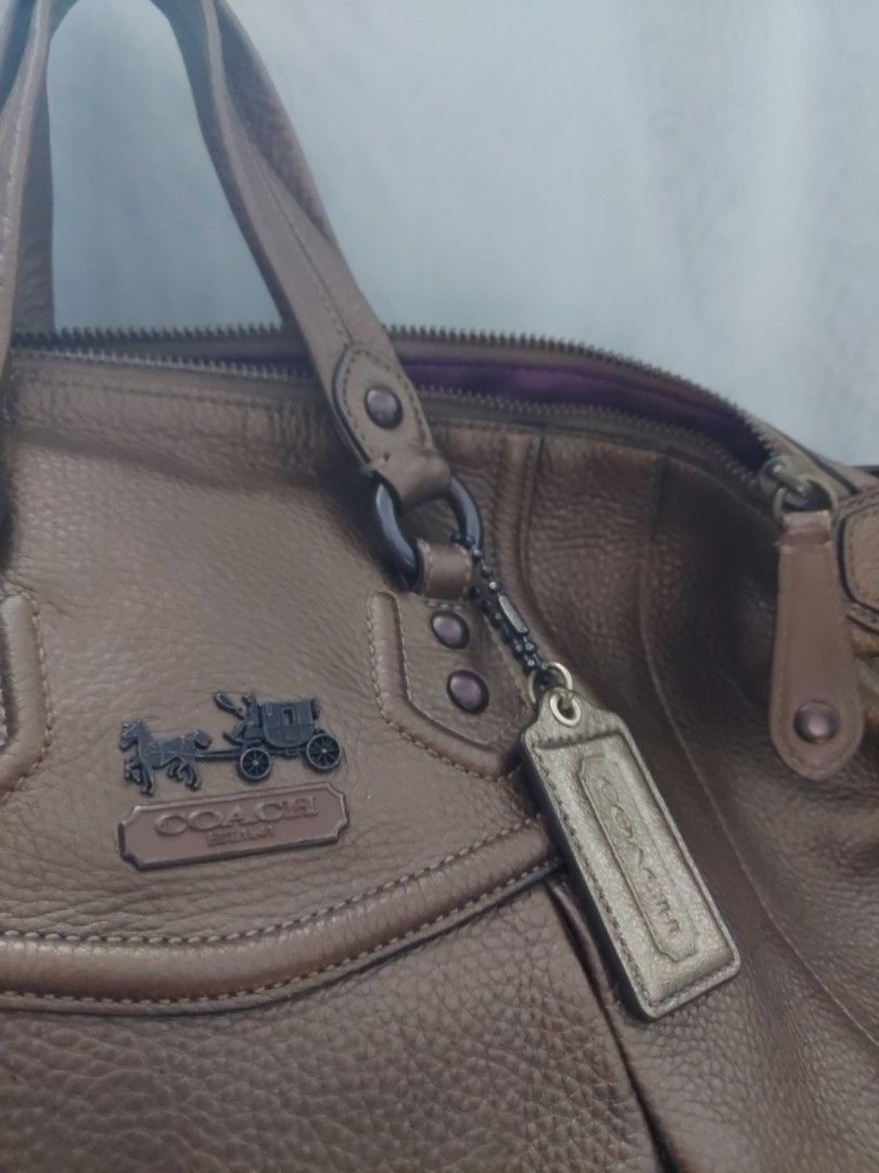 Coach Metallic Bronze Leather Handbag (Category: Luxury Bags & Wallets) located in Quezon City. Submitted by never_a_clutter (Listing ID 1469534563, Image 2). Description: - Brand: Coach AUTHENTIC - Material: Textured pebble leather in metallic bronze - Design: Pleated details with classic Coach carriage logo plaque and gunmetal hardware - Straps: Dual top handles and a detachable shoulder strap with stylish chain links - Interior: Vibrant purple