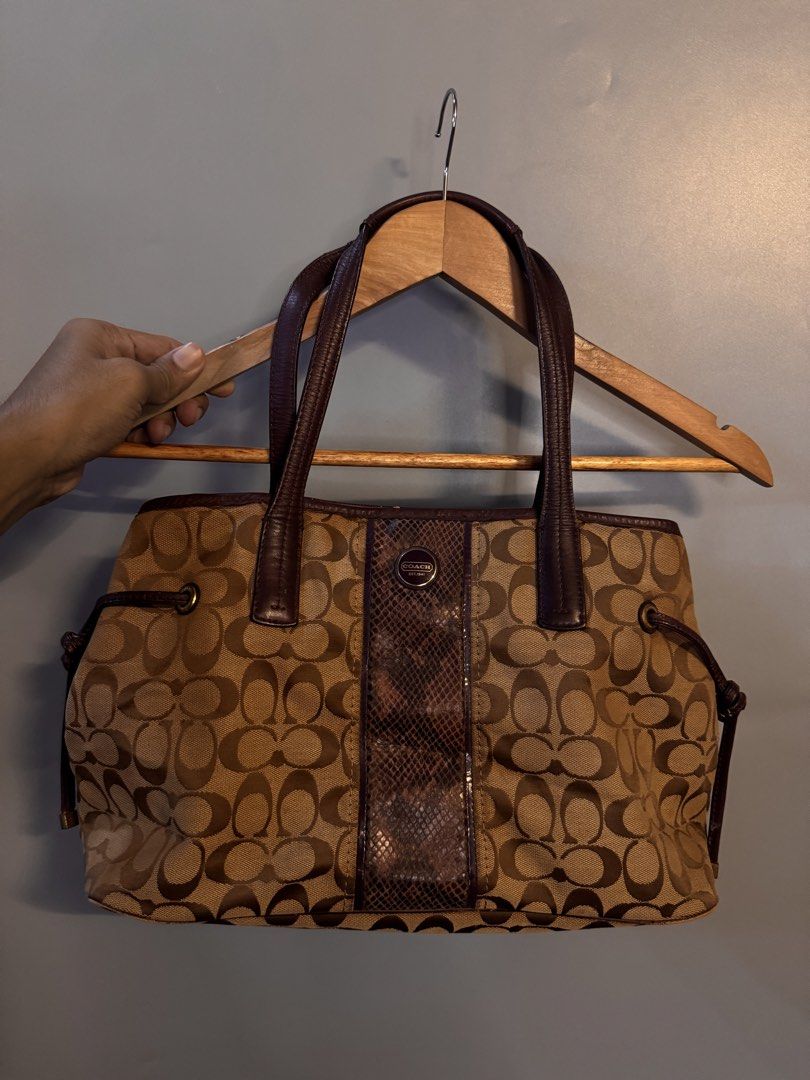 Coach Signature C Brown Tote Bag with Python Stripe (Category: Luxury Bags & Wallets) located in Alaminos. Submitted by outfitcheck.ph (Listing ID 1469512834, Image 1). Description: - Brand: Coach - Material: Signature C canvas with textured python print panel and leather trim - Color: Classic brown with dark brown accents - Features: Side drawstrings, spacious interior, and brass hardware bottom feet - Condition: Minor wear on some edges, otherw
