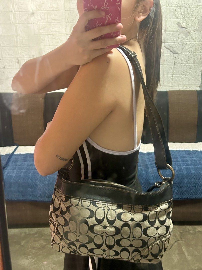 Coach Signature C Monogram Hobo Shoulder Bag (Category: Luxury Bags & Wallets) located in San Jose del Monte. Submitted by jenflores33996 (Listing ID 1469406076, Image 1). Description: - Authentic Coach signature C monogram shoulder bag - Black and beige canvas body with dark leather trim and strap - Secure zipper top closure - Stylish brass tone hardware rings on the sides - Comfortable drop length for shoulder or underarm carry.