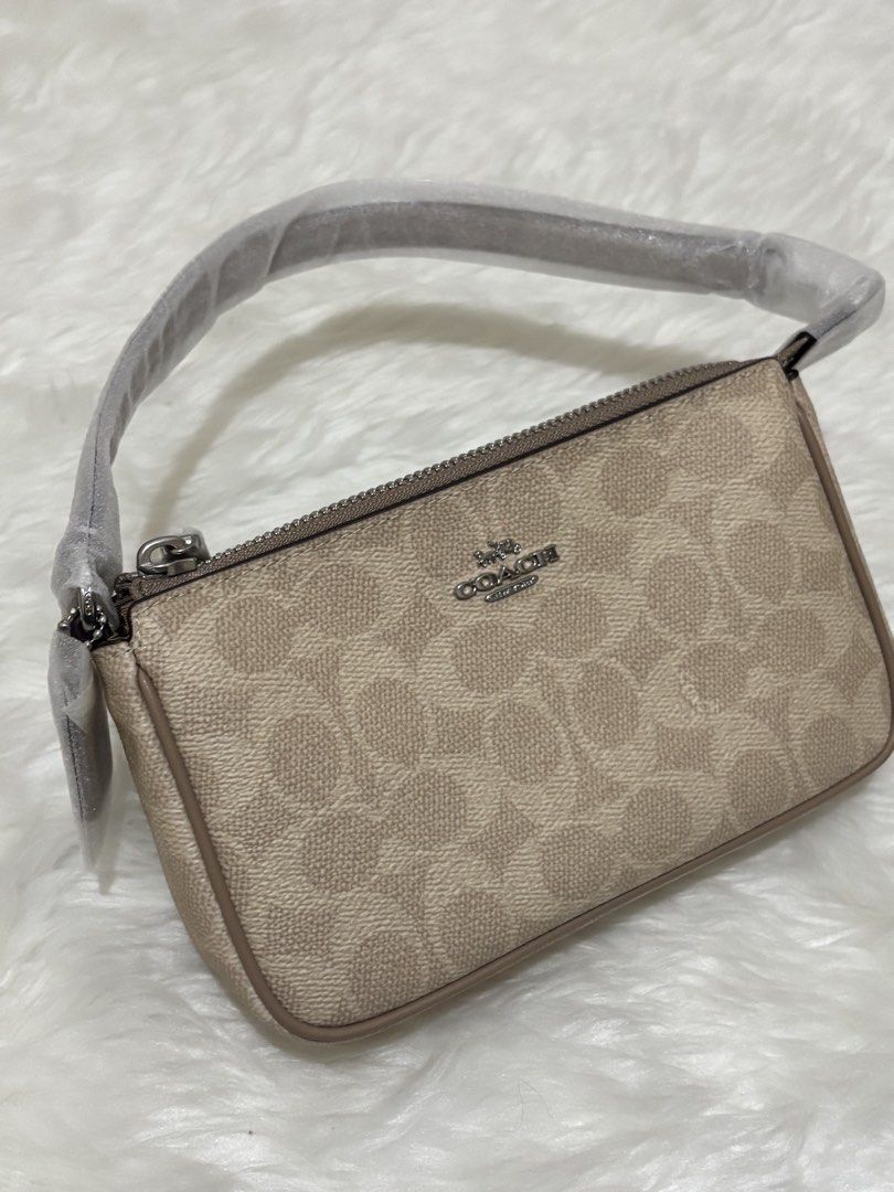 Coach Signature Canvas Mini Ruby Shoulder Bag (Category: Shoulder Bags) located in Muntinlupa City. Submitted by maaarjj (Listing ID 1469408920, Image 1). Description: - Brand: Coach - Style: Mini shoulder bag - Material: Beige signature monogram coated canvas - Hardware: Silver-tone with zip top closure - Condition: Brand new, handle still wrapped in original protective plastic - Features: Compact size, perfect for everyday essentials and goes w