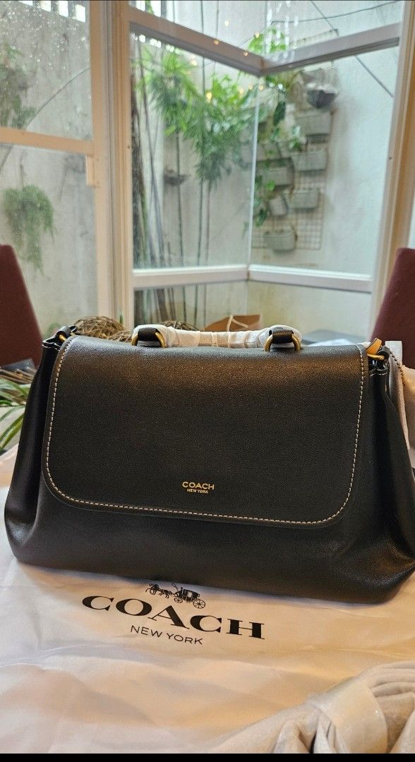 Coach Slouchy rogue top handle (Category: Luxury Bags & Wallets) located in Rizal. Submitted by vanbdc24 (Listing ID 1469507092, Image 1). Description: - Brand new Coach black leather bag - Elegant gold-tone hardware and gold foil Coach New York logo - Stylish structured flap top with white contrast stitching - Convenient top handle design with protective wrapping still on - Includes original white dust bag with classic carriage and logo print - 