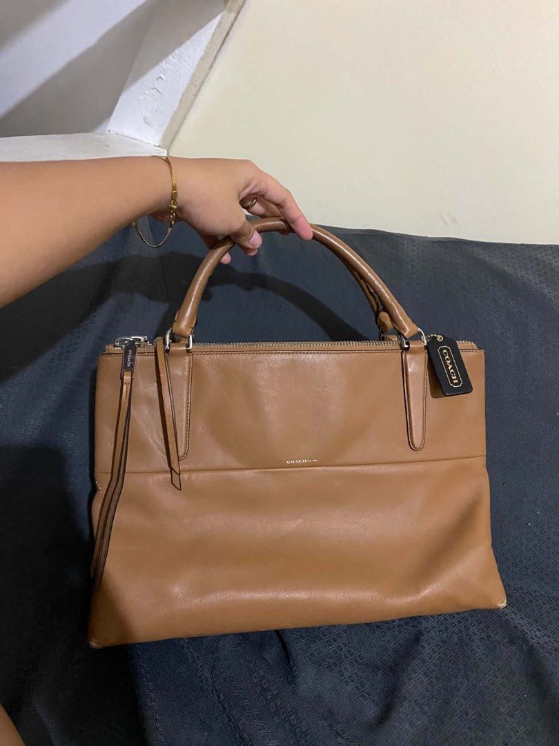 Coach Tan Leather Handbag (Category: Luxury Bags & Wallets) located in Manila. Submitted by melissatua68314 (Listing ID 1469517866, Image 1). Description: - Coach tan leather handbag - Dual top handles with secure zip top closure - Spacious interior lined with black fabric - Multiple zipped inner compartments for easy organization - Silver-tone hardware and signature black Coach hangtag - Coach creed patch stamped inside (Style # L1393-30348) - S