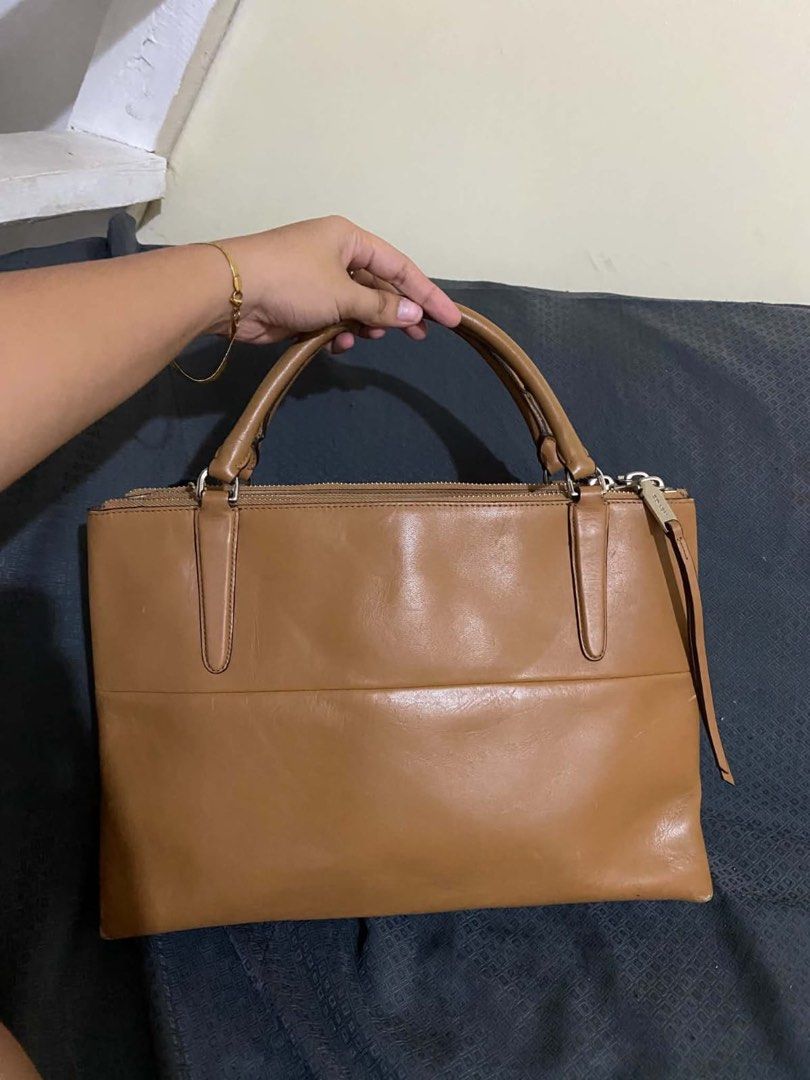 Coach Tan Leather Handbag (Category: Luxury Bags & Wallets) located in Manila. Submitted by melissatua68314 (Listing ID 1469517866, Image 2). Description: - Coach tan leather handbag - Dual top handles with secure zip top closure - Spacious interior lined with black fabric - Multiple zipped inner compartments for easy organization - Silver-tone hardware and signature black Coach hangtag - Coach creed patch stamped inside (Style # L1393-30348) - S