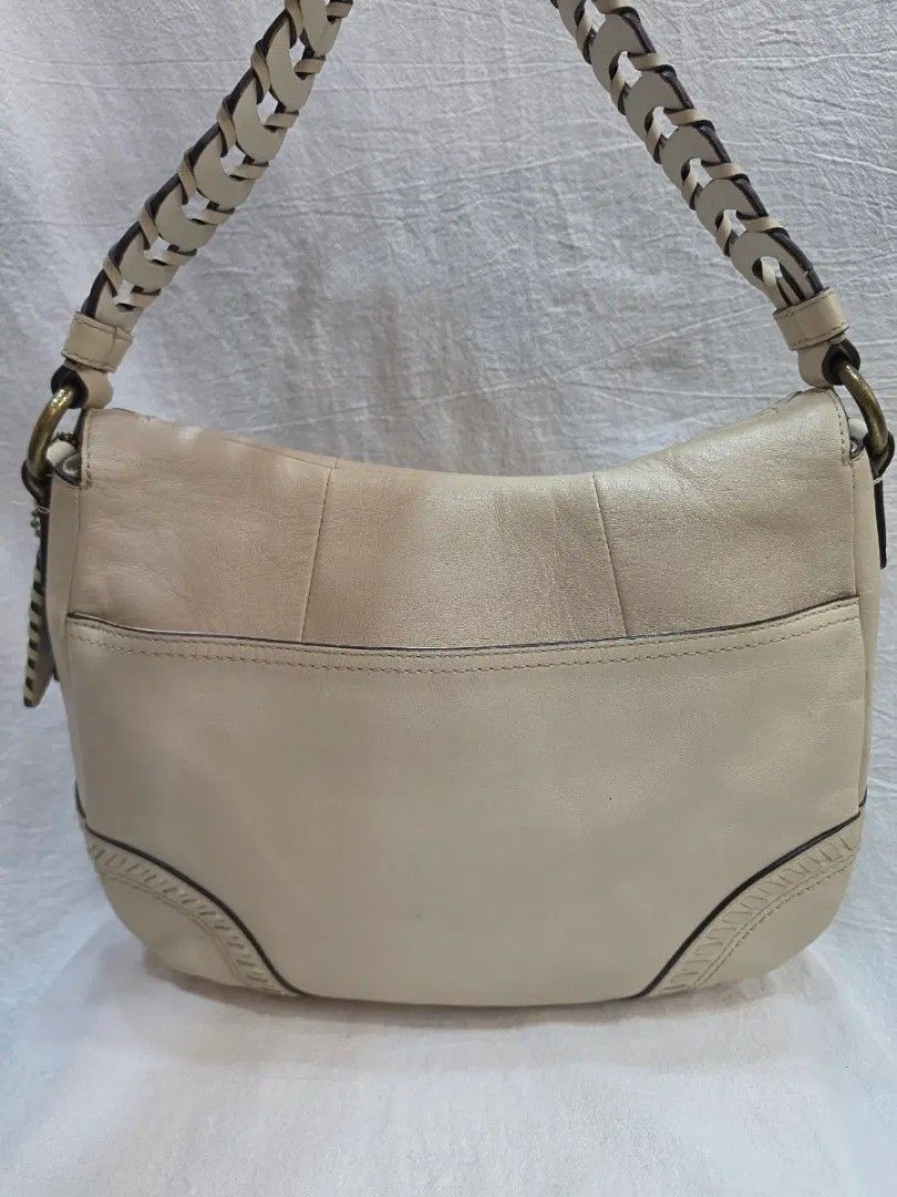 Coach White Leather Shoulder Bag Braided Strap (Category: Shoulder Bags) located in Manila. Submitted by preloved439 (Listing ID 1469419806, Image 2). Description: Authentic Coach white leather shoulder bag with a braided strap and brass hardware. Front flap closure with a buckle accent and decorative stitching along the edges. Back slip pocket included. Hangtag attached to the side ring. Clean neutral shade that matches many outfits. Regular wea