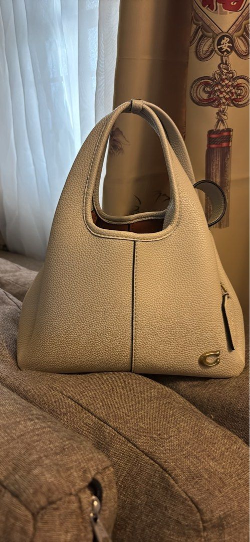 Coach White Leather Tote Shoulder Bag with Strap (Category: Luxury Bags & Wallets) located in Imus. Submitted by charliexcx44 (Listing ID 1469477579, Image 3). Description: - Brand: Coach - Material: Genuine pebbled leather - Color: Off-white with gold-tone hardware and signature 'C' logo tag - Straps: Double top handles and an adjustable, detachable shoulder strap - Interior: Tan lining with Coach creed patch - Condition/Style: Roomy daily carry