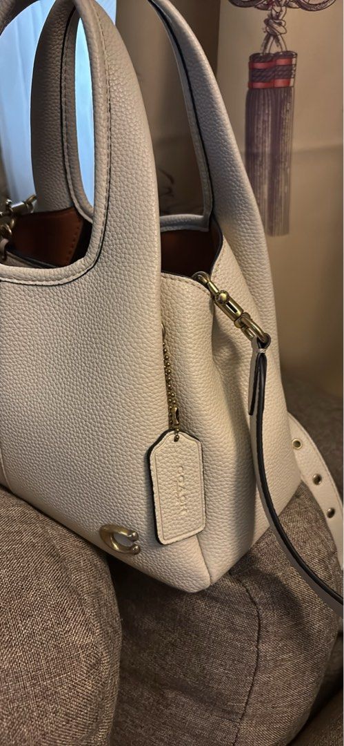 Coach White Leather Tote Shoulder Bag with Strap (Category: Luxury Bags & Wallets) located in Imus. Submitted by charliexcx44 (Listing ID 1469477579, Image 2). Description: - Brand: Coach - Material: Genuine pebbled leather - Color: Off-white with gold-tone hardware and signature 'C' logo tag - Straps: Double top handles and an adjustable, detachable shoulder strap - Interior: Tan lining with Coach creed patch - Condition/Style: Roomy daily carry