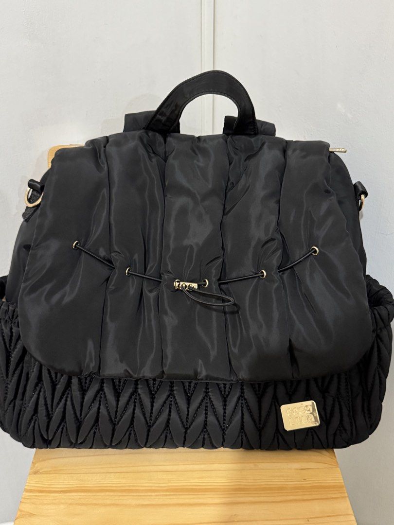 Coco Lala Quilted Black Nylon Diaper Bag (Category: Backpacks) located in Paranaque City. Submitted by shopdecalidad (Listing ID 1469439181, Image 1). Description: - Color: Black with chic gold hardware accents - Material: Durable and lightweight quilted nylon - Closure: Wide front flap with secure drawstring detail - Storage: Spacious main compartment with mesh zipper and slip pockets, plus exterior side pockets - Comfort: Structured top handle 