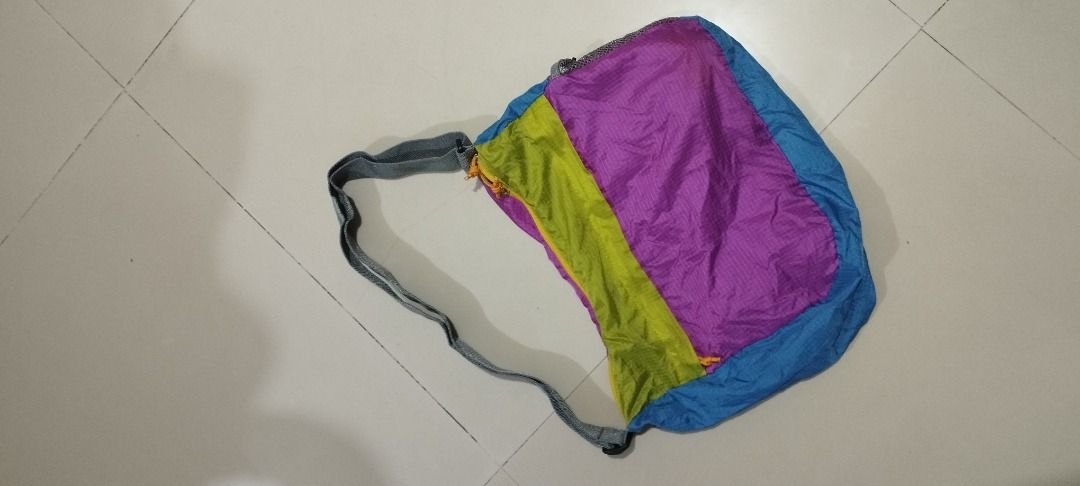 Coleman Pocketable Shoulder Bag (Category: Shoulder Bags) located in Koronadal. Submitted by jrdar (Listing ID 1469572076, Image 2). Description: - Brand: Coleman - Color: Vibrant multi-color (purple, blue, lime green) with grey strap - Material: Lightweight, durable ripstop nylon - Design: Folds compactly into its own attached pouch with a convenient clip hook - Usage: Ideal for travel, hiking, gym, or quick grocery runs.