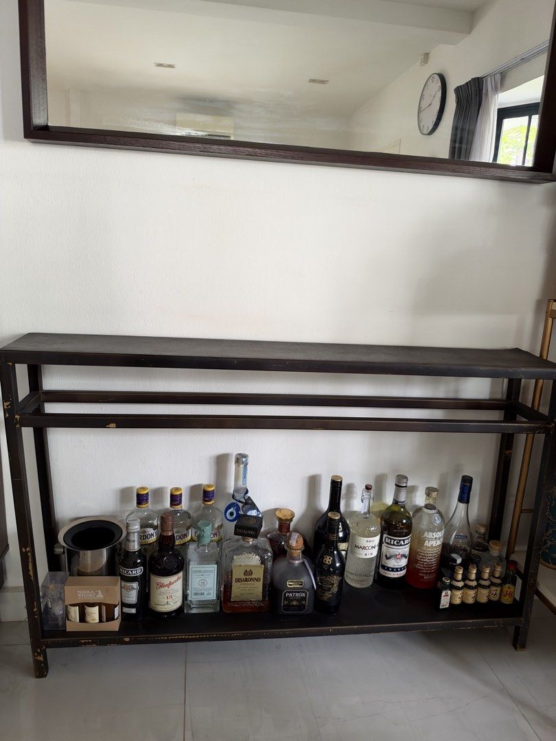 Console table (Category: Tables & Sets) located in Singapore. Submitted by superrrbbbbb (Listing ID 1469406805, Image 1). Description: Alcohol not included - Type: Console table - Material: black metal/iron frame Measurement: 122cm (L) x 77cm (H) 20cm (D) - Storage: Open bottom shelf - Placement: Fits perfectly behind a sofa or against an entryway wall - Condition: Some wear and tear along the edges (the look is industrial so there’s some marks a