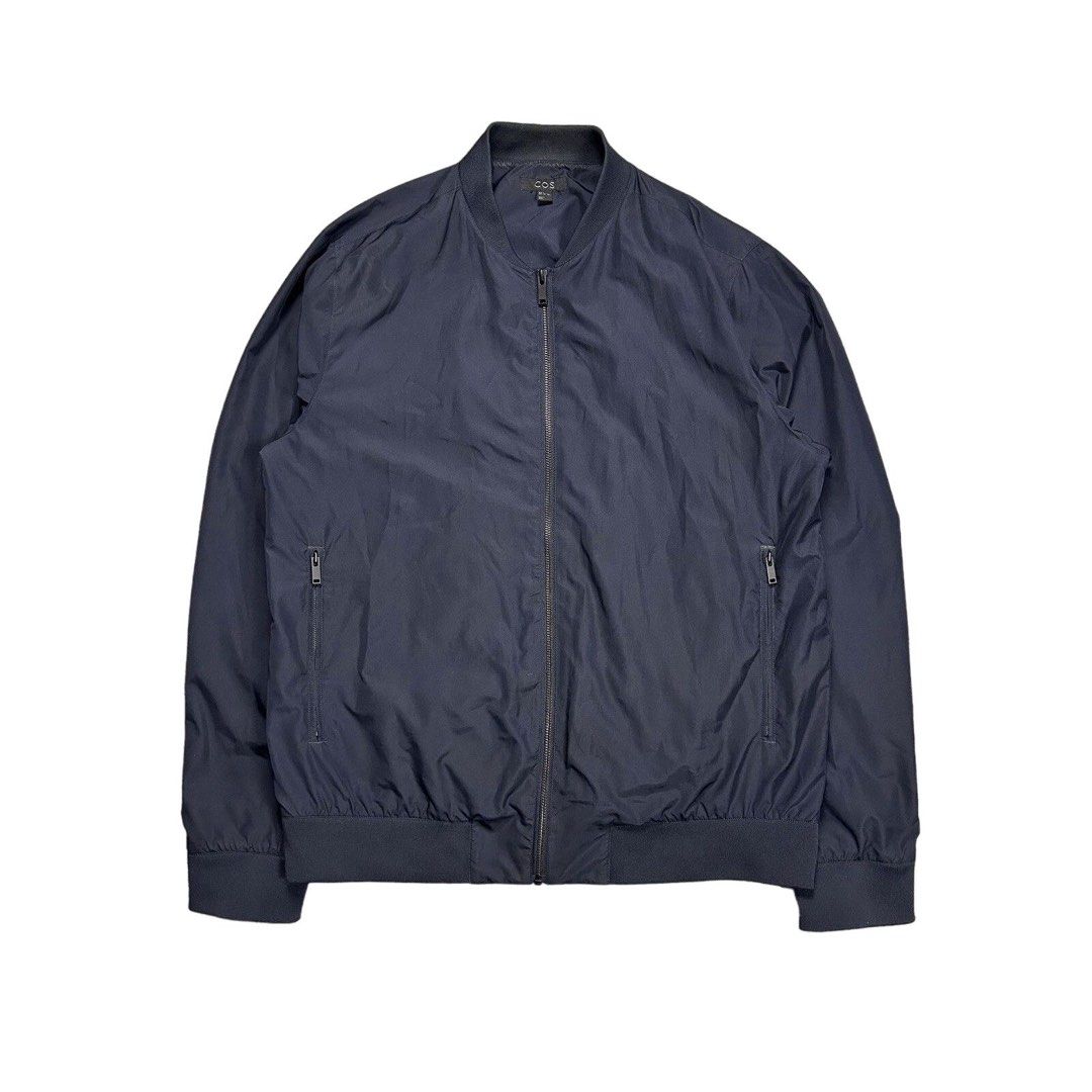 COS Navy Blue Zip Bomber Jacket Size XS (Category: Coats, Jackets and Outerwear) located in Manila. Submitted by ba_thrifted (Listing ID 1469525624, Image 1). Description: - Brand/Model: COS navy blue bomber jacket - Size: EUR XS - Design: Clean minimalist style with full front zipper - Pockets: Two secure zippered side pockets - Details: Comfortable ribbed collar, cuffs, and hem - Material: Lightweight fabric, ideal for layering in cooler weathe