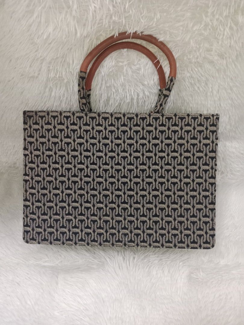 Cowed Ycaki Patterned Tote Bag with Brown Handles (Category: Cross-body Bags) located in Quezon City. Submitted by zhelcloset01 (Listing ID 1469509207, Image 2). Description: - Brand: Cowed Ycaki - Design: Black and cream patterned tote bag with brown faux leather accents - Features: Double top handles, matching luggage tag, secure main zippered compartment, and interior slip pockets - Interior: Tan fabric lining - Condition: Excellent, clean wit