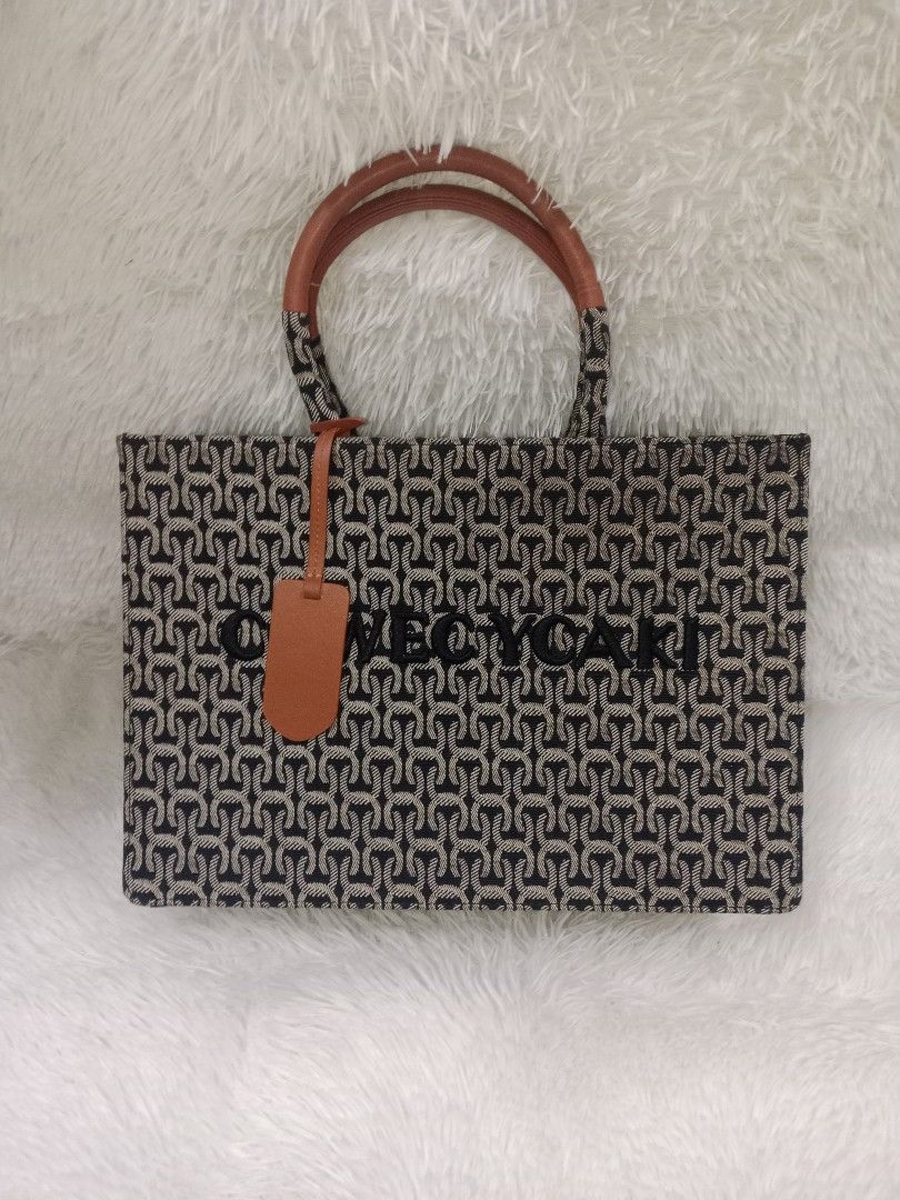 Cowed Ycaki Patterned Tote Bag with Brown Handles (Category: Cross-body Bags) located in Quezon City. Submitted by zhelcloset01 (Listing ID 1469509207, Image 1). Description: - Brand: Cowed Ycaki - Design: Black and cream patterned tote bag with brown faux leather accents - Features: Double top handles, matching luggage tag, secure main zippered compartment, and interior slip pockets - Interior: Tan fabric lining - Condition: Excellent, clean wit