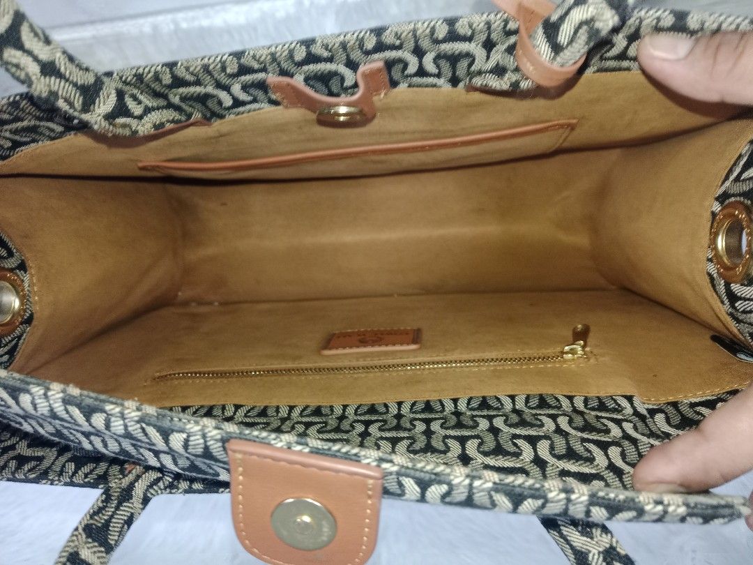 Cowed Ycaki Patterned Tote Bag with Brown Handles (Category: Cross-body Bags) located in Quezon City. Submitted by zhelcloset01 (Listing ID 1469509207, Image 3). Description: - Brand: Cowed Ycaki - Design: Black and cream patterned tote bag with brown faux leather accents - Features: Double top handles, matching luggage tag, secure main zippered compartment, and interior slip pockets - Interior: Tan fabric lining - Condition: Excellent, clean wit
